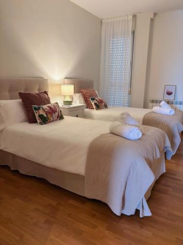 two large beds in a room with a window at Apartamento Garnacha Rioja Aire Acondicionado,Wifi,BUS Búho in Lardero