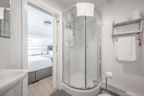 a bathroom with a shower and a sink and a bed at Blue Swallow in Penrith