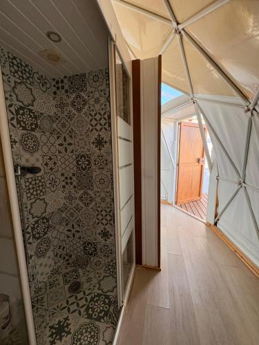 una habitación con una pared de cristal con una pared en ADAMA Glamping, en Chiclana de la Frontera
