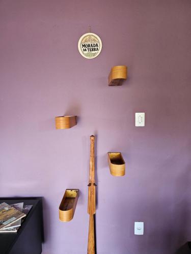 a wall with wooden baskets and a baseball bat at Morada da Terra Lapinha da Serra in Santana do Riacho