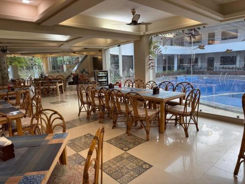 a restaurant with tables and chairs and a swimming pool at White Sands Resort & Spa in Varca