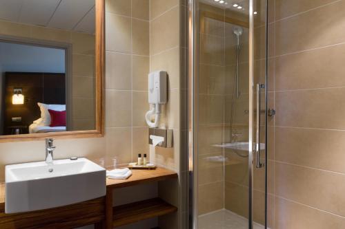 a bathroom with a sink and a shower at Abbaye des Capucins Spa & Resort in Montauban