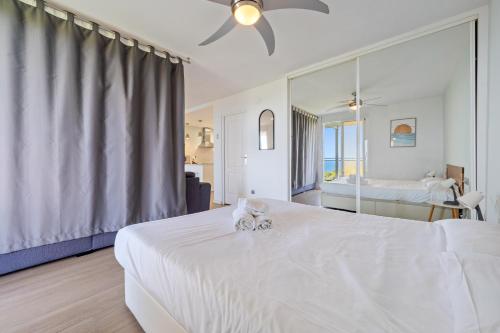 un lit blanc avec un chat assis au-dessus dans l'établissement Clauhomes Vista Al Mar, à Salou
