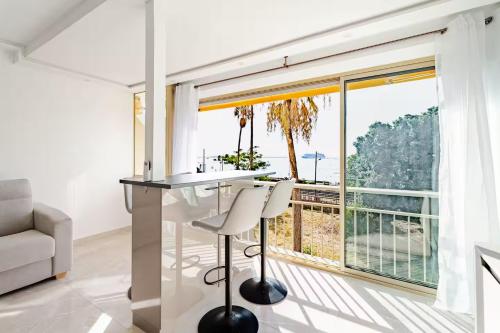 a white kitchen with a table and a large window at Luxury Apartment with Sea View and Private Beach Access in Cannes