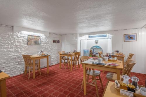 a dining room with wooden tables and chairs at Blue Swallow in Penrith