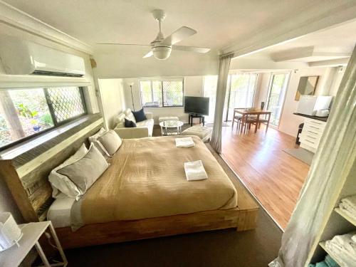 a bedroom with a large bed and a living room at Gin's Rainforest stay -pet friendly in Mount Tamborine