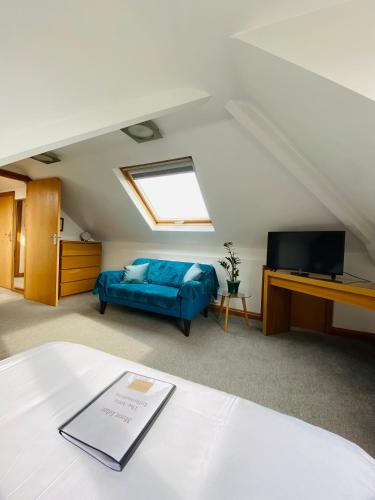 a living room with a blue couch and a television at Mooredge Guest House in Whitby