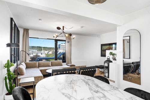 クリスティアンサンにある360 view Penthouse l Home office l 60 sqm balconyの白いリビングルーム(テーブル、椅子付)
