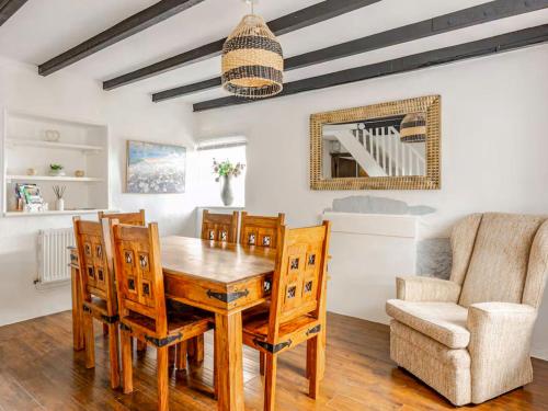 ein Esszimmer mit einem Holztisch und Stühlen in der Unterkunft Sunnyside Cottage Retreat in Penwithick