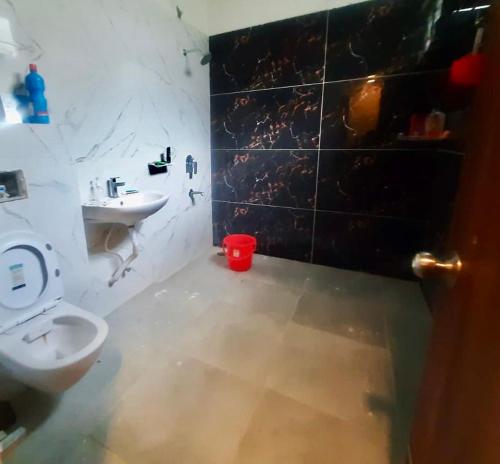 a bathroom with a white toilet and a sink at SR Farm Stay in Turkapally