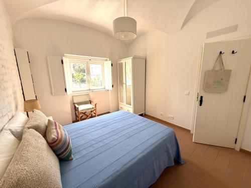 ein Schlafzimmer mit einem blauen Bett und einem Fenster in der Unterkunft Casa das Laranjeiras in Torrão