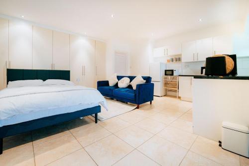 a bedroom with a bed and a couch and a kitchen at Studio House by Brookland Stays Serviced Accommodation Short Lets Feltham with Free WiFi in New Bedfont