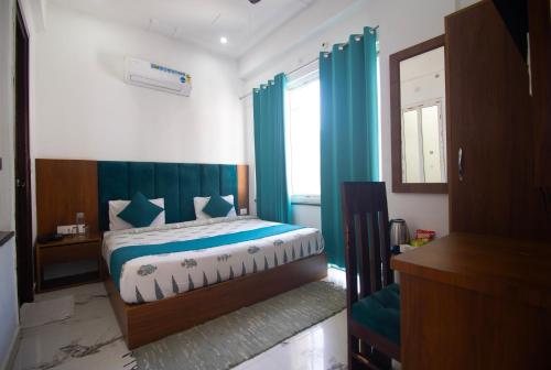 a bedroom with a bed with blue curtains and a window at Hotel Parth Inn in Rishīkesh