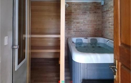a bath tub in a room with a brick wall at Beautiful Home In Klostar Ivanic in Kloštar Ivanić