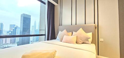 Un dormitorio con una cama con vistas a una ciudad. en The Axon Place Bukit Bintang, en Kuala Lumpur