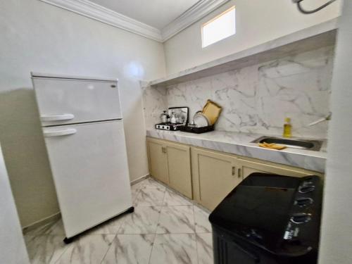 Oulad AkkouにあるResidence Hamada Laayoune - Family & Traveler Apartmentsの白い冷蔵庫とシンクのあるキッチン