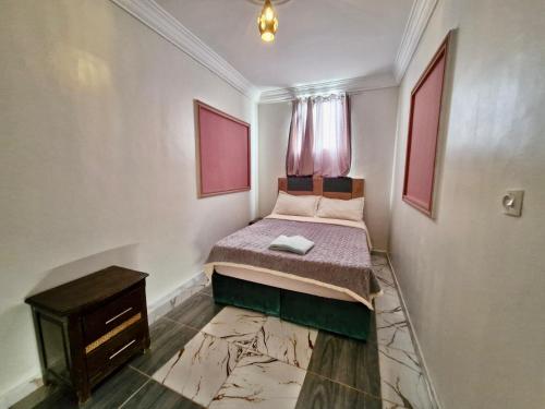 Oulad AkkouにあるResidence Hamada Laayoune - Family & Traveler Apartmentsのベッドとテーブルのある小さな寝室