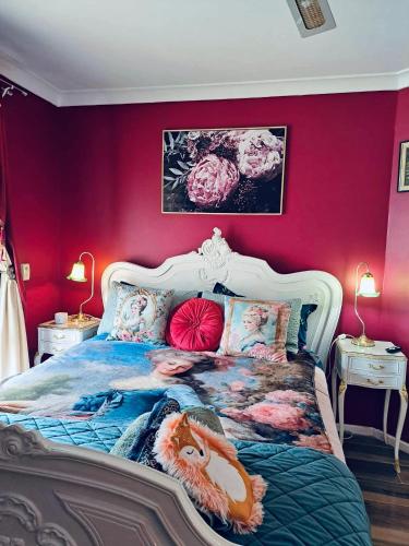 a bedroom with a large bed with pink walls at Bettys Mountain Cottage in York