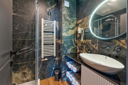 a bathroom with a sink and a mirror at Villa Di Montagna wellness & spa in Zlatibor