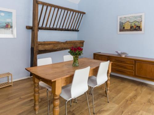 a dining room with a wooden table and white chairs at Ingleby Barn - 27946 in Battersby