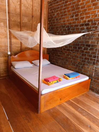 a bed with a mosquito net on top of it at Avocados homestay in Banlung