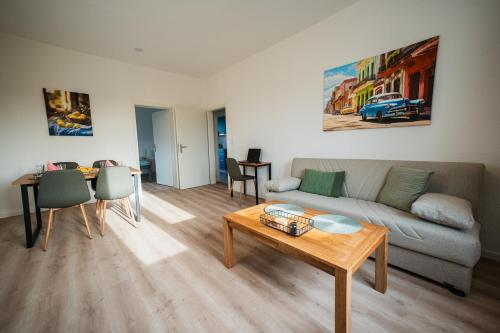 ein Wohnzimmer mit Sofa und Tisch in der Unterkunft Zentrale Wohlfühlwohnung - Ideal für Ihren Urlaub oder die Geschäftsreise in Magdeburg