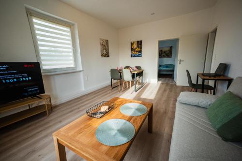 una sala de estar con un sofá y una mesa en Zentrale Wohlfühlwohnung - Ideal für Ihren Urlaub oder die Geschäftsreise, en Magdeburgo