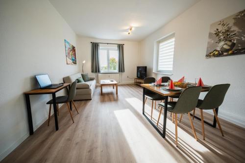 una sala de estar con una mesa y un sofá en Zentrale Wohlfühlwohnung - Ideal für Ihren Urlaub oder die Geschäftsreise, en Magdeburgo