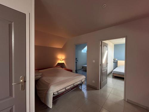 a bedroom with a bed and a door leading to a bedroom at MAISON DE VACANCES AVEC PISCINE INTERIEURE - Le Grand Champagne in Saint-Victeur