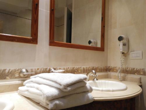 a pile of towels sitting on a bathroom sink at Hotel A&B Internacional in Buenos Aires