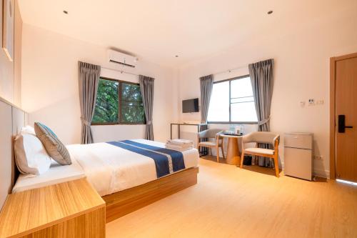 a bedroom with a bed and a table and chairs at Selina Place Hotel in Pattaya South