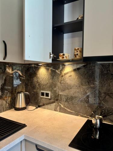 a kitchen with white cabinets and a counter top at Allegra Sofia Cozy Luxury near Business Park and 10 min to Sofia airport in Sofia