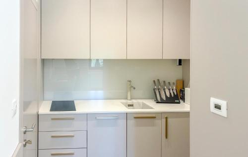 a white kitchen with white cabinets and a sink at Gorgeous Apartment In Palit in Palit