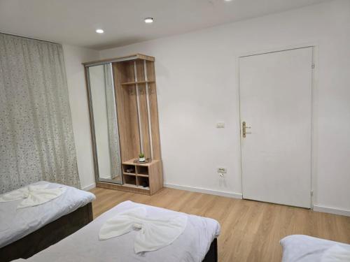 a room with two beds and a mirror at Neva's Hostel in Librazhd