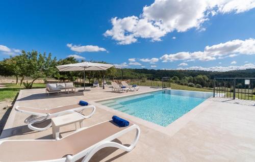 a swimming pool with lounge chairs and an umbrella at Son Pons in Randa
