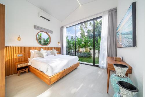 Un dormitorio con una cama y una ventana grande. en Oasis Pandawa 6A - Sun, Sand and Serenity - 3BR Villa with Private Pool, en Ungasan