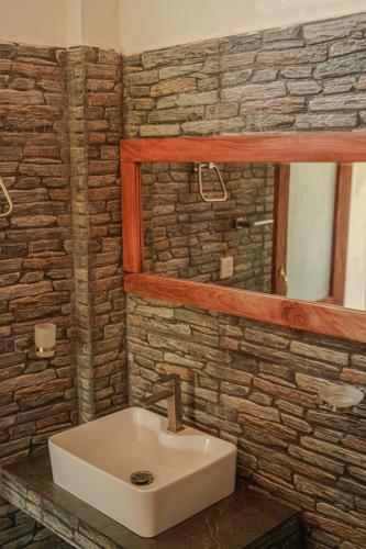 a bathroom with a sink and a stone wall at Surf View Point Ahangama in Ahangama