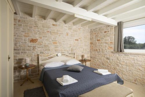a bedroom with a bed and a brick wall at Villa Piccolo Paradiso with Heated Pool, Jacuzzi & Sauna in Rovinjsko Selo