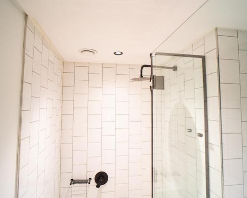 a bathroom with a shower with a glass door at Modern Studio Steps from Ratanga Park in Cape Town