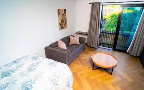 a living room with a couch and a table at Modern Studio Steps from Ratanga Park in Cape Town