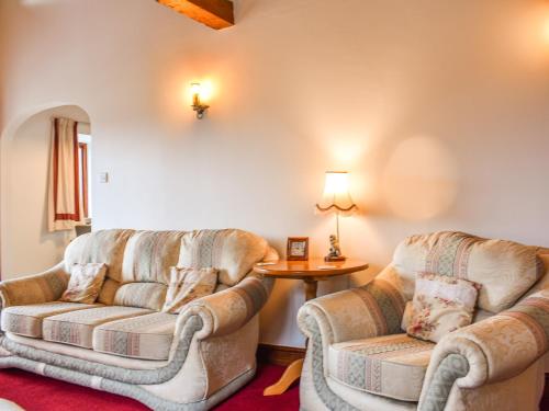 a living room with two chairs and a couch at Spring Grove in Pooley Bridge