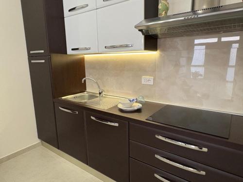 a kitchen with brown cabinets and a sink at Residenza Orchidea in Tarquinia