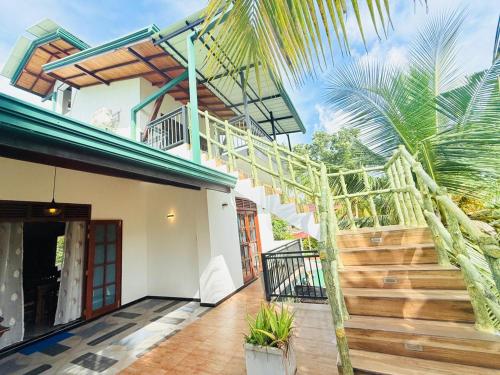 a house with a staircase leading to the front door at Shells Villa Hikkaduwa in Hikkaduwa