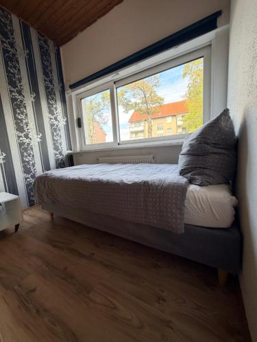 a bedroom with a bed and a large window at Riva Single Apartment in Hamm
