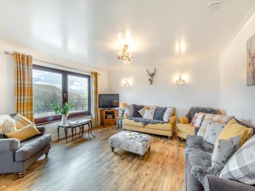 Una sala de estar con dos sofás y un televisor. en Towford Farm Bungalow, en Jedburgh
