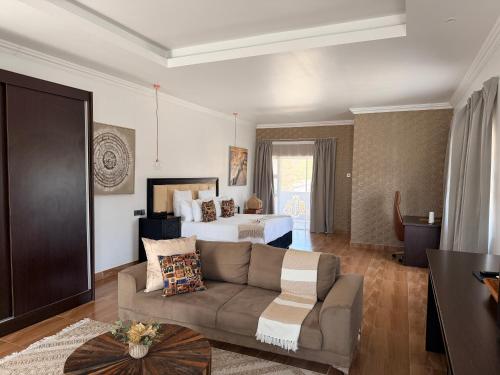 a living room with a couch and a bed at 10 on Pauling Hotel Bulawayo in Bulawayo