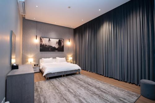 Un dormitorio con una cama blanca y cortinas negras. en فلل بكمباوند خاص, en Riad