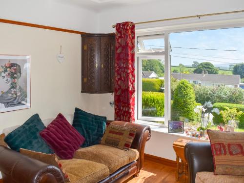 a living room with a couch and a large window at Riversong in Rhyl