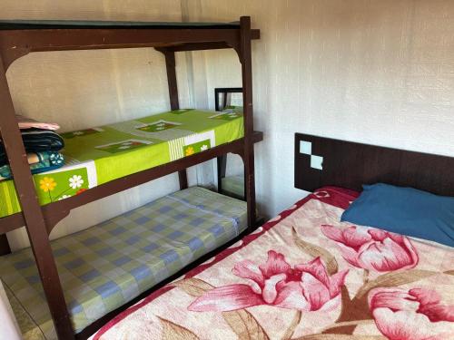 een slaapkamer met twee stapelbedden met roze bloemen erop bij Cielo abierto in Maldonado