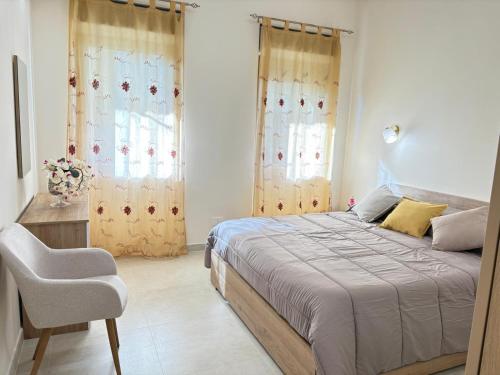 a bedroom with a bed and a chair and windows at Residenza Orchidea in Tarquinia